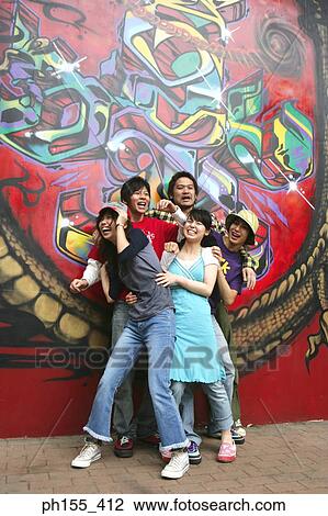 Two young women and three young men laughing in front of a graffiti View Large Photo Image Stock Image - Two young women and three young men laughing in front of a graffiti. Fotosearch