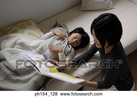 Stock Photo - High angle view of a mid adult woman teaching her son. Fotosearch