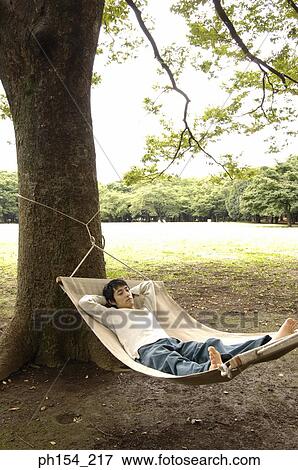Stock Photo - High angle view of a young man lying in a hammock. Fotosearch