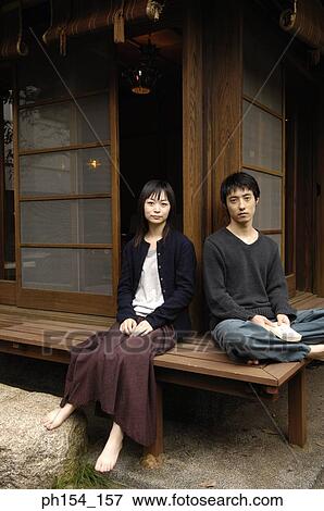 Stock Photo - Portrait of a young couple sitting. Fotosearch