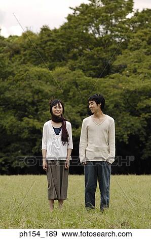 Portrait of a young woman standing with a young man View Large Photo Image Stock Photo - Portrait of a young woman standing with a young man. Fotosearch