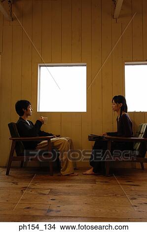 Side profile of a young couple sitting near windows View Large Photo Image Picture - Side profile of a young couple sitting near windows. Fotosearch