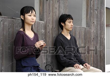 Stock Photo - Side profile of a young couple sitting. Fotosearch