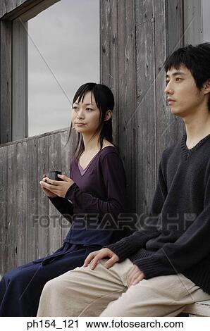 Young couple sitting on a bench View Large Photo Image Stock Image - Young couple sitting on a bench. Fotosearch
