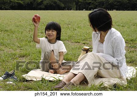 Young woman sitting with her daughter on a mat View Large Photo Image Stock Image - Young woman sitting with her daughter on a mat. Fotosearch