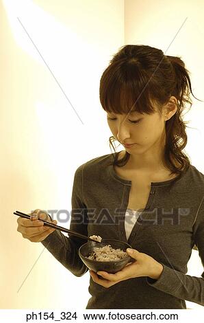 Close-up of a young woman eating rice View Large Photo Image Picture - Close-up of a young woman eating rice. Fotosearch