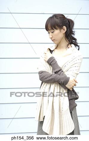Close-up of a young woman hugging herself View Large Photo Image Stock Photograph - Close-up of a young woman hugging herself. Fotosearch