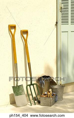 Picture - Gardening equipment in front of a door. Fotosearch