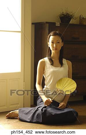 Portrait of a young woman holding a fan View Large Photo Image Stock Image - Portrait of a young woman holding a fan. Fotosearch