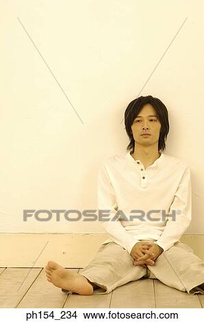 Young man leaning against a wall View Large Photo Image Picture - Young man leaning against a wall. Fotosearch