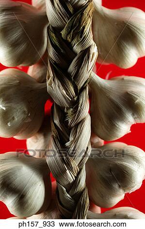 Stock Image - Garlic on red background, close-up. Fotosearch