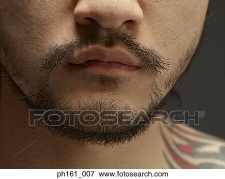 Stock Photo - Man with goatee and tattoo, close-up. Fotosearch