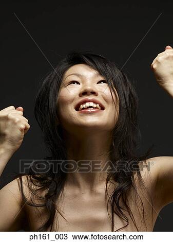 Portrait of a young woman with her fists up in the air View Large Photo Image Stock Image - Portrait of a young woman with her fists up in the air. Fotosearch