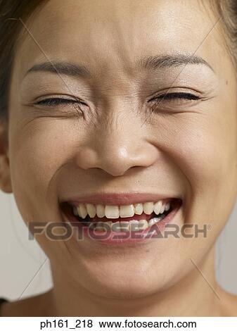 Stock Photo - Young woman smiling with eyes closed. Fotosearch