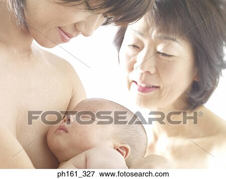 A mother carrying her baby, and a mature woman looking on View Large Photo Image Stock Photo - A mother carrying her baby, and a mature woman looking on. Fotosearch