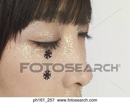 Close-up of woman's face with glitter and black snowflakes View Large Photo Image Stock Photo - Close-up of woman's face with glitter and black snowflakes . Fotosearch