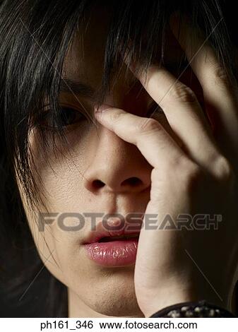 Close-up of young man with hand to face View Large Photo Image Stock Photograph - Close-up of young man with hand to face. Fotosearch