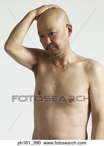 Stock Image - Mature bald guy touching his head, shirtless. Fotosearch