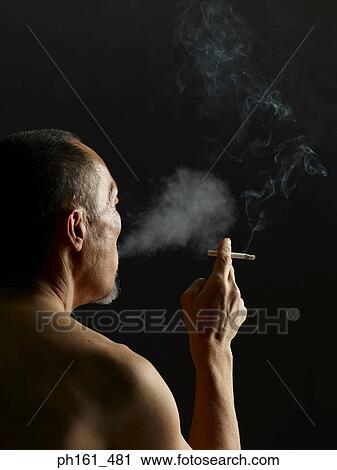 Mature man holding a cigarette and smoking, back view View Large Photo Image Stock Image - Mature man holding a cigarette and smoking, back view. Fotosearch