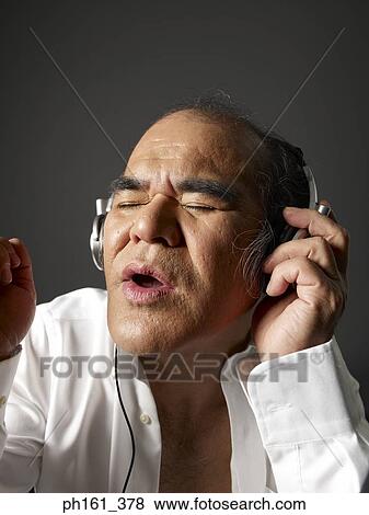Mature man wearing a white shirt, listening to music View Large Photo Image Stock Photo - Mature man wearing a white shirt, listening to music. Fotosearch