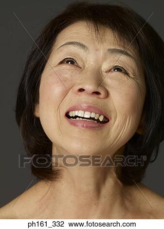 Stock Image - Portrait of mature woman laughing, close-up. Fotosearch