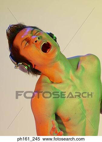 Stock Photography - Shirtless man with headphones, screaming. Fotosearch
