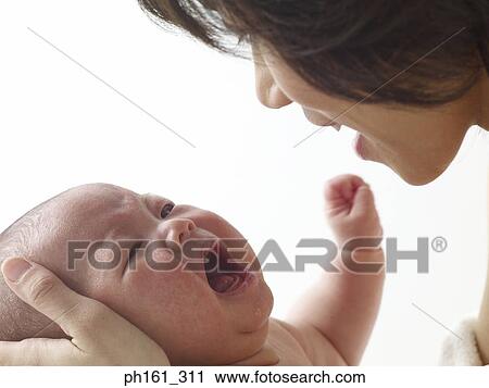 Stock Image - Woman comforting a crying baby. Fotosearch
