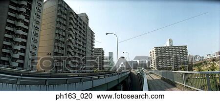 Stock Image - View of road surrounded by buildings. Fotosearch