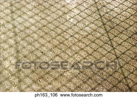Stock Photograph - Shadow of fence on grass. Fotosearch