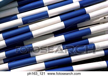 Stock Image - White and blue striped poles, stacked. Fotosearch