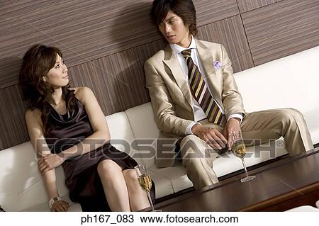 A couple relaxing by the sofa, with champagne View Large Photo Image Stock Image - A couple relaxing by the sofa, with champagne. Fotosearch