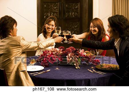 Two couples making a toast at a dinner table View Large Photo Image Stock Photo - Two couples making a toast at a dinner table. Fotosearch