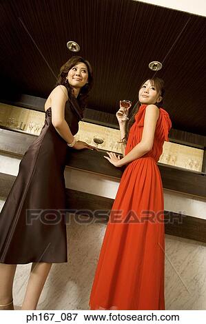 Two women relaxing by the bar, low angle View Large Photo Image Stock Photo - Two women relaxing by the bar, low angle. Fotosearch