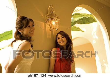 Picture - Two women standing by corridor. Fotosearch