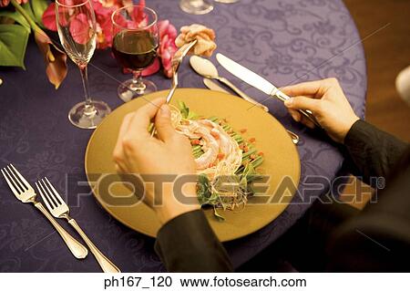 Stock Image - Young man having dinner, close-up. Fotosearch