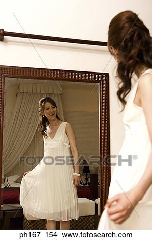 Young woman at reflection in front of mirror View Large Photo Image Picture - Young woman at reflection in front of mirror. Fotosearch