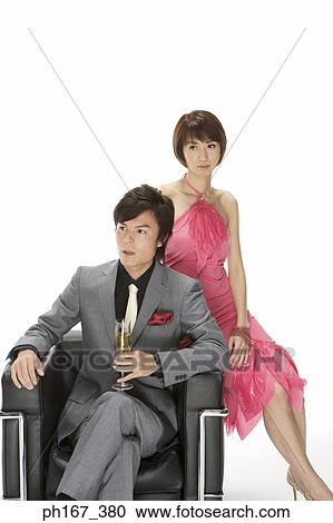 Couple sitting on a sofa View Large Photo Image Stock Image - Couple sitting on a sofa. Fotosearch