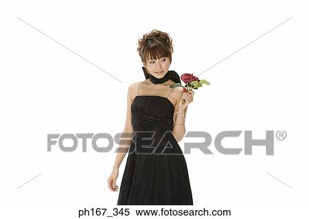 Stock Photography - Portrait of a woman in black dress, holding flowers. Fotosearch