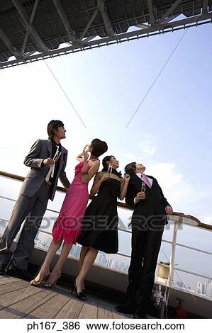 Stock Photograph - Two couples onboard a cruise ship, staring at the sky. Fotosearch