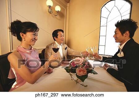 Two men and a woman toasting with wine View Large Photo Image Stock Photo - Two men and a woman toasting with wine. Fotosearch