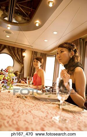 Stock Image - Two women enjoying a meal. Fotosearch