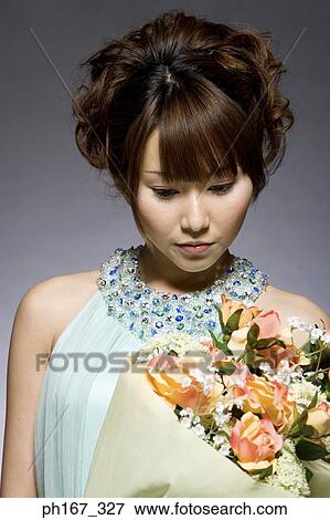 Stock Photo - Woman holding a bouquet of flowers. Fotosearch