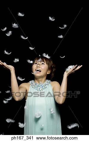 Stock Image - Woman playing with feathers. Fotosearch