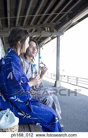 Couple in traditional Japanese clothing sitting at train station View Large Photo Image Stock Image - Couple in traditional Japanese clothing sitting at train station. Fotosearch