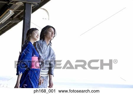 Stock Image - Couple in traditional Japanese clothing, holding hands. Fotosearch