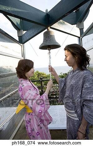 Picture - Couple ringing a bell. Fotosearch