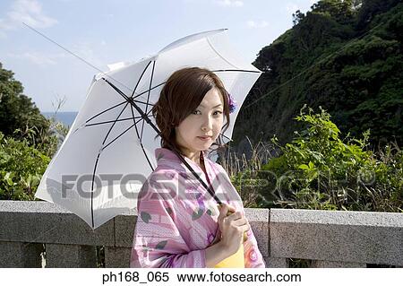 Woman in kimono standing by the ocean View Large Photo Image Stock Photography - Woman in kimono standing by the ocean. Fotosearch