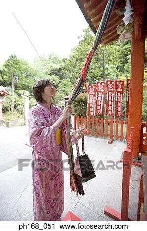 Woman in kimono tugging the rope at the temple View Large Photo Image Stock Image - Woman in kimono tugging the rope at the temple. Fotosearch