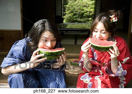 Stock Photo - Couple biting into water melon. Fotosearch