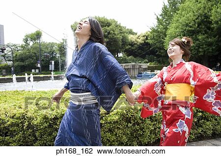 Couple in traditional Japanese clothing walking in the park, laughing View Large Photo Image Stock Image - Couple in traditional Japanese clothing walking in the park, laughing. Fotosearch
